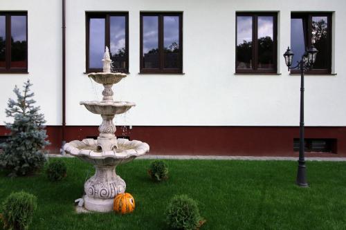 a fountain in the grass with pumpkins in front of a building at Amso Residence in Sibiu