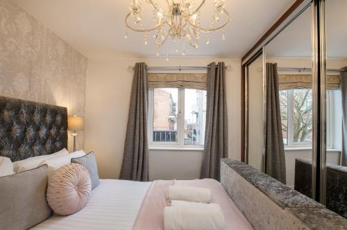a bedroom with a large bed and a chandelier at Holgate Lodge in York