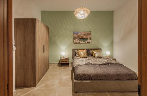 a bedroom with a bed and a wooden cabinet at St Julians`s Boho Apartments in Is-Swieqi