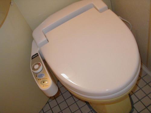 a white toilet in a bathroom with a control panel at Hotel Tsubame Hills in Tsubame