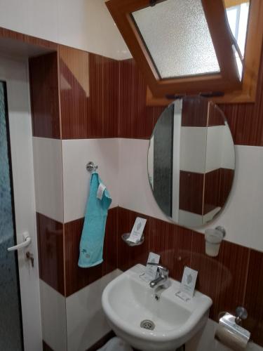 a bathroom with a sink and a mirror at Пандова къща in Sandanski