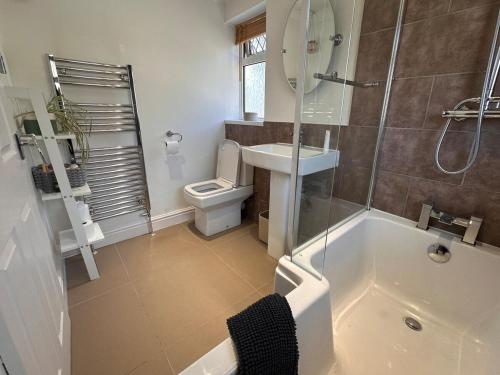 a bathroom with a tub and a toilet and a sink at 3 bed house in Risca in Risca