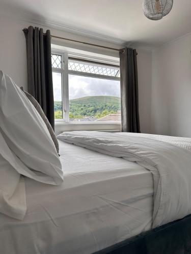 a bedroom with a large bed with a window at 3 bed house in Risca in Risca