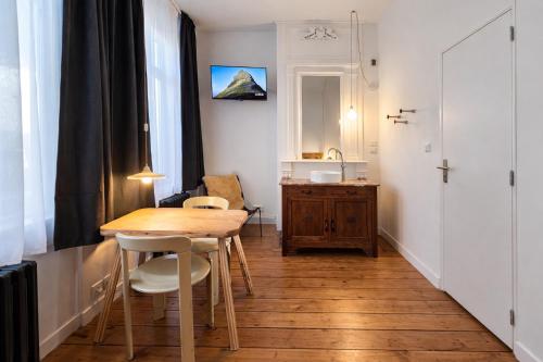 a small room with a wooden table and chairs at LA MAISON FIVES - Esprit Hôtel Design - Lille in Lille