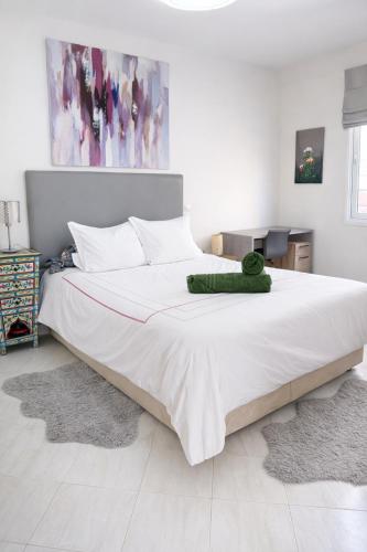 a bedroom with a large bed with a green towel on it at Villa grand large in Tamraght Ouzdar