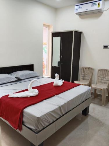 a bedroom with a bed with white towels on it at SRC Mahal in Killai