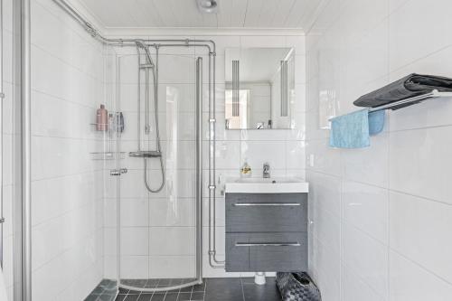 a white bathroom with a shower and a sink at Fantastisk havsutsikt i Ulebergshamn in Hunnebostrand