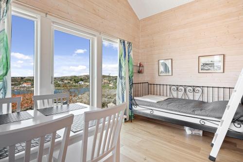 a room with a bed and a balcony with windows at Fantastisk havsutsikt i Ulebergshamn in Hunnebostrand