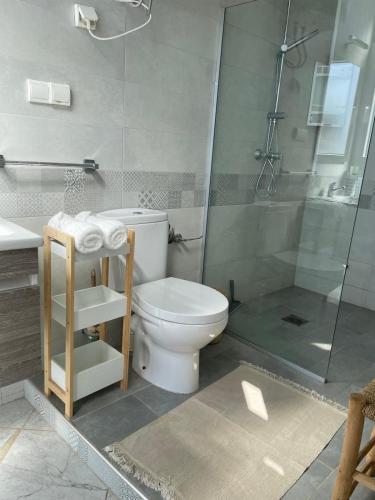 a bathroom with a toilet and a glass shower at Villa grand large in Tamraght Ouzdar