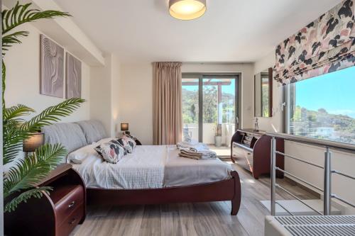 a bedroom with a bed and a large window at Villa Saktouris in Saktoúria