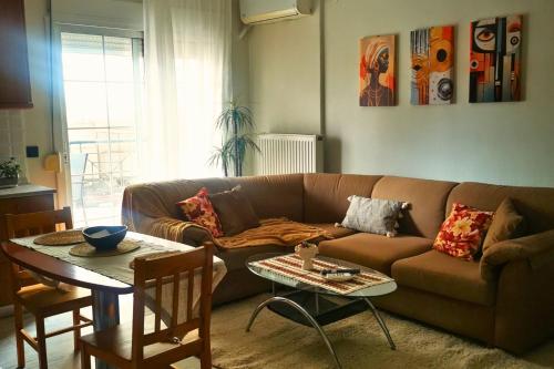 a living room with a brown couch and a table at Sotiris Urban Stay in Xanthi