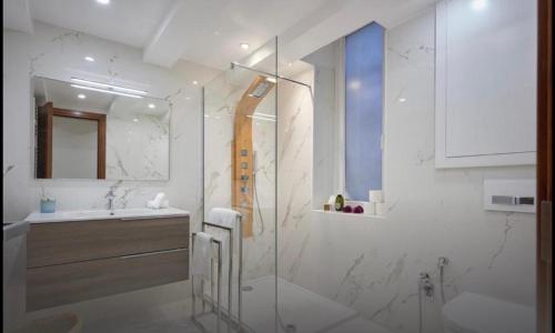 a white bathroom with a sink and a shower at Central luxury duplex in Cannes