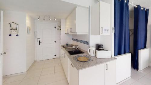 a small kitchen with white cabinets and a sink at Holiday 3401 in Roses