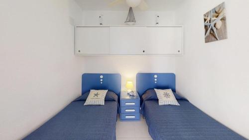 two beds in a room with blue beds at Holiday 3401 in Roses