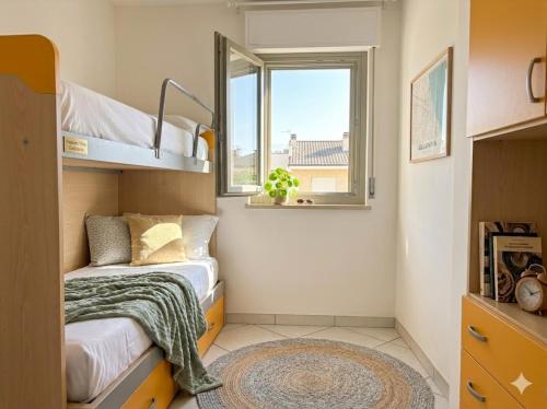 a small bedroom with two bunk beds and a window at PIOPPETO EST - Premium Villas in Giulianova