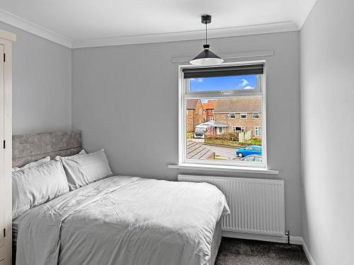 a white bedroom with a bed and a window at Modern Contractor House - Lockable Gated Parking in Kiveton Park