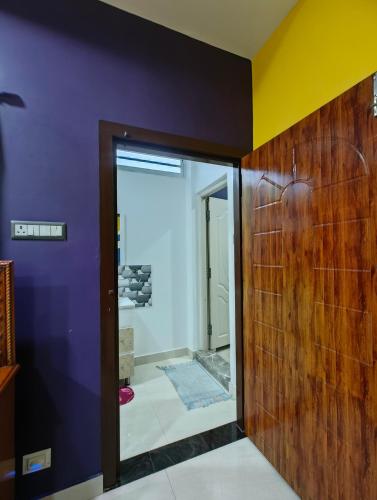 a bathroom with purple walls and a glass door at Aashray Independent Homestay Dibrugarh in Dibrugarh