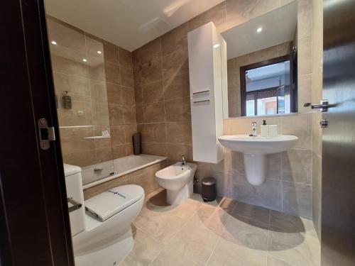 a bathroom with a toilet and a sink and a tub at Aldea Bricia 201 in Posada de Llanes