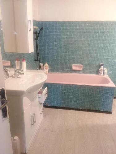 a bathroom with a pink tub and a sink at Maison neuvecelle in Neuvecelle