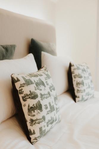 a white bed with two pillows on it at The Half Moon Inn in Dean