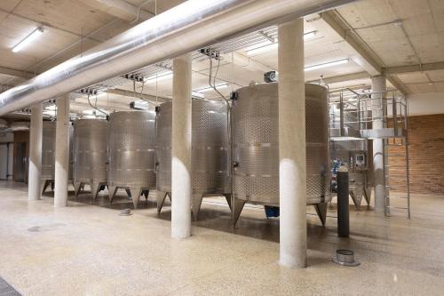 a row of silver tanks in a building at Winery La Gora in Irig