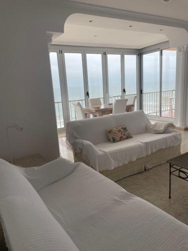 a living room with a couch and a table and chairs at Apartamento con Vistas Panorámicas in Sueca