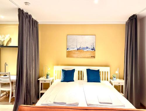 a bedroom with a large bed with blue pillows at VibeStudio A2- Central Vienna 1090 - 50m2 - Self Check-In - AC in Vienna