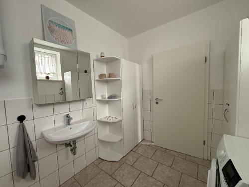 a white bathroom with a sink and a shower at Horizont 360 in Kitzingen