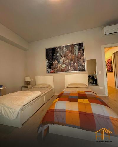a bedroom with two beds and a painting on the wall at VVR6 Rooms by Homes in Ancona in Ancona