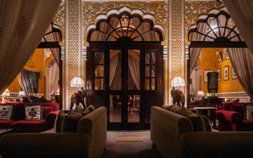 a room with chairs and a door in a building at Rohet Garh in Rohat
