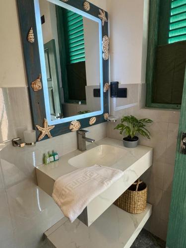 a bathroom with a sink and a mirror at Hotel Catamaran Bay by Ayur Ayur in Negombo
