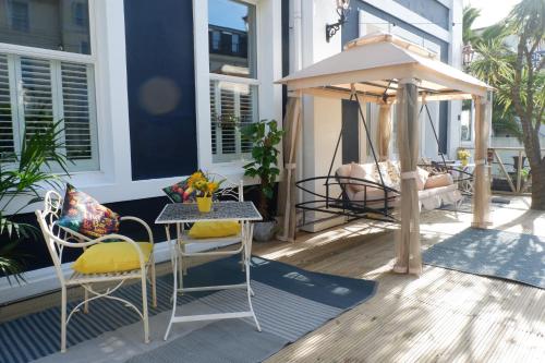 a table and chairs on a porch with a gazebo at The Southbank Torquay by the sea in Torquay