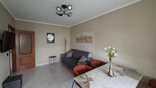 a living room with a couch and a table with a vase of flowers at A casa di Gina in Airasca