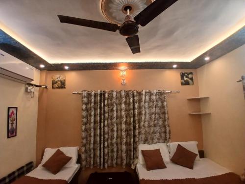 a ceiling fan in a living room with a couch at ROOMS vala in Varanasi