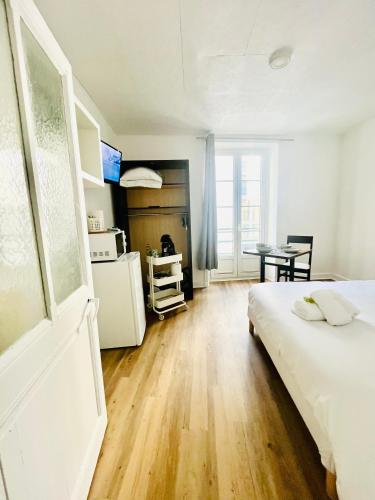a bedroom with a bed and a kitchen with a table at Apparthotel Beauregard 12 cœur de Nantes WIFI in Nantes