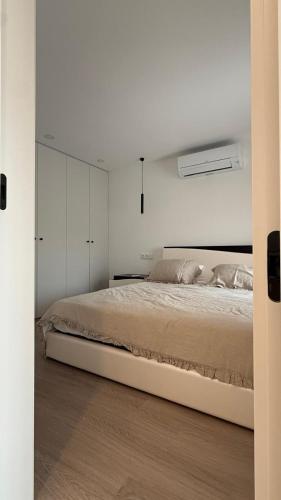 a bedroom with a large bed with white walls at Casa Portela Viana do Castelo in Viana do Castelo
