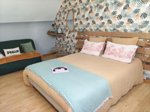 a bedroom with a bed with pink and blue sheets at Entre terre et baie à 15 mn du Mont-Saint-Michel in Pontaubault