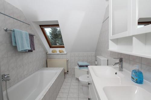 ein Badezimmer mit einer Badewanne, einem Waschbecken und einem WC in der Unterkunft Sea Lounge in Eckernförde
