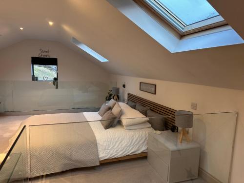 a bedroom with a large bed and a skylight at The Old Quarry Hideaway in Cowling
