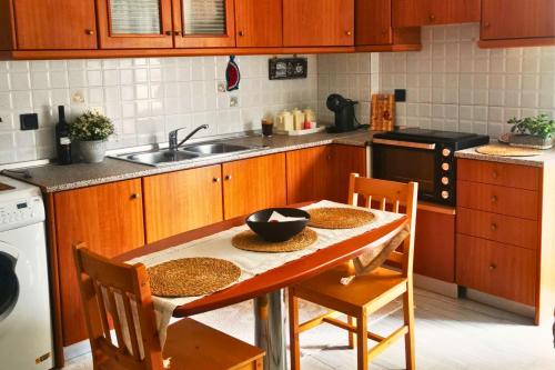 a kitchen with a table and chairs and a sink at Sotiris Urban Stay in Xanthi