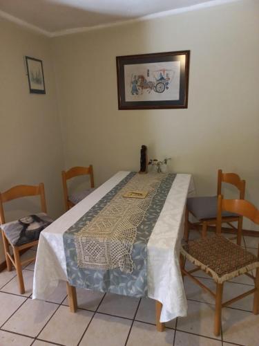a dining room with a table and two chairs at Bird cottage in Barrydale