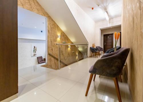 a living room with a staircase and a chair at Hotel Crystal in Pećinci