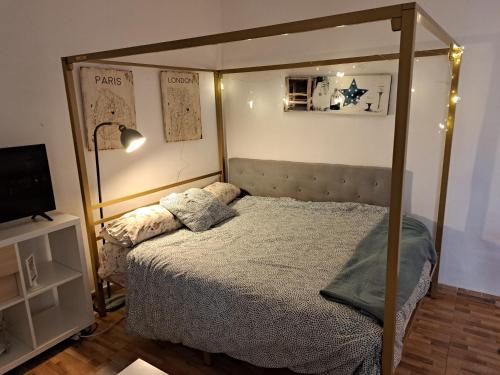 a bedroom with a canopy bed and a television at Retales in Cartagena