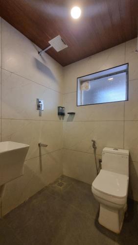 a bathroom with a toilet and a sink at Hotel Arena in Mahe