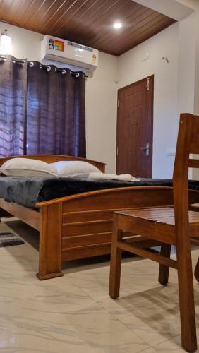 a bedroom with a wooden bed and a wooden chair at Hotel Arena in Mahe