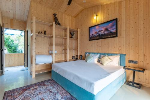 a bedroom with a bed in a room with wooden walls at River and Roots Resort, Riverside Boutique Stay , Bonfire, Scenic Views in Dehradun