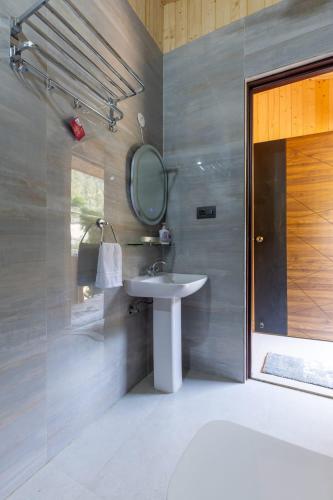 a bathroom with a sink and a mirror at River and Roots Resort, Riverside Boutique Stay , Bonfire, Scenic Views in Dehradun