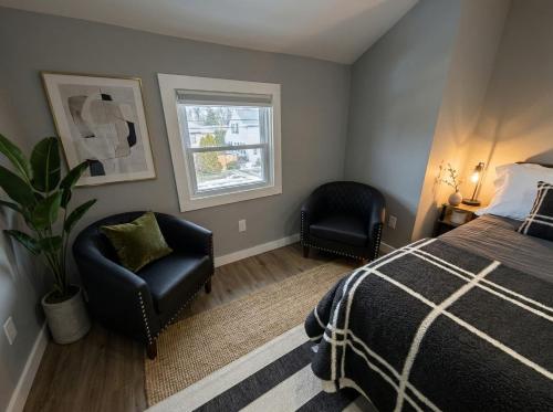 a bedroom with a bed and a chair and a window at Sleek Modern Villa - Centrally Located in Wilmington