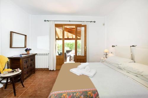 a bedroom with a large white bed and a desk at Villa Maina by Villa Plus in El Port