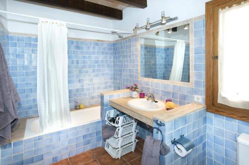 a blue tiled bathroom with a sink and a mirror at Villa Maina by Villa Plus in El Port